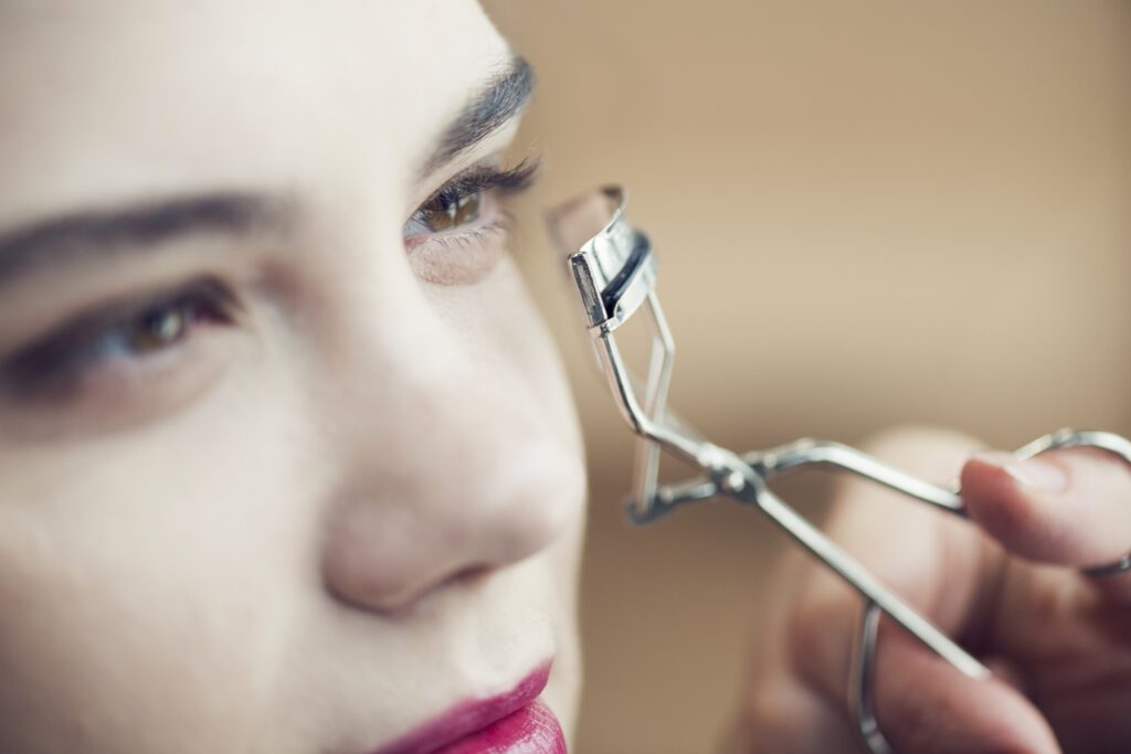 rosto de mulher aplicando curvex de cílios