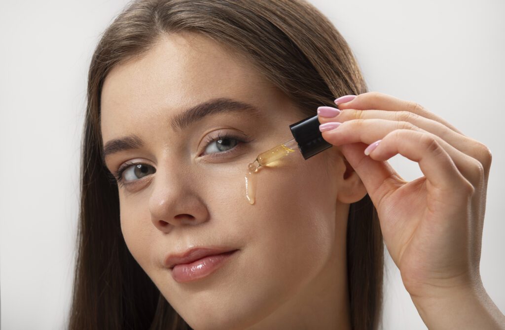 mulher passando sérum no rosto para o preparo da maquiagem