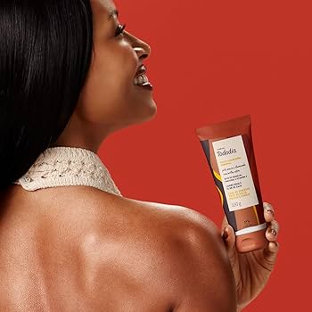 mulher segurando uma bisnaga de Geleia Desodorante Iluminadora Tododia Jambo Rosa e Flor de Caju