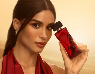 Essencial Safran Feminino 100 ml, mulher com o perfume na mão